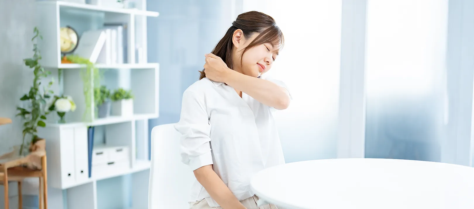 首のこりに悩む女性